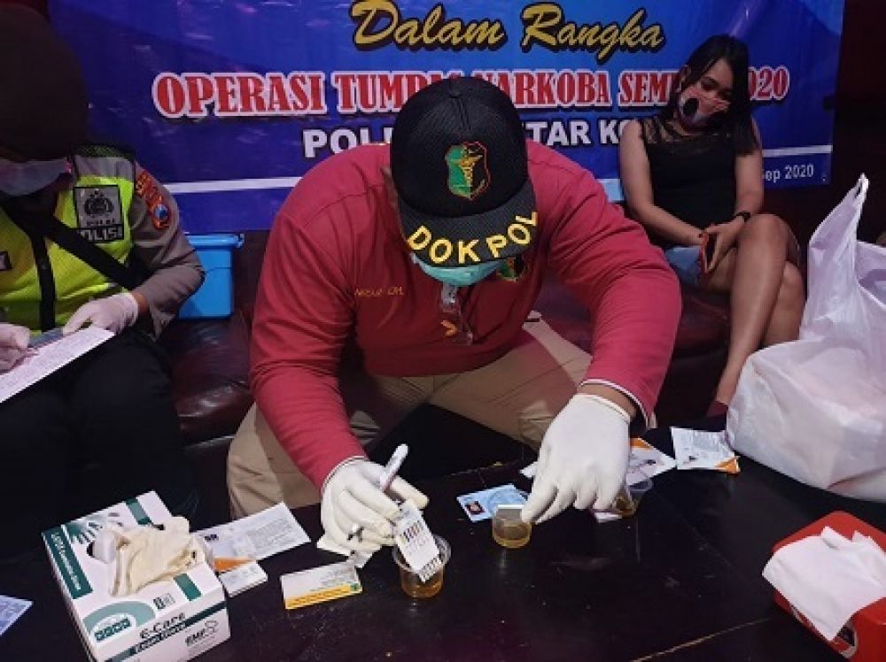 Dengan teliti polisi lakukan pemeriksaan Urine. SP/ Les