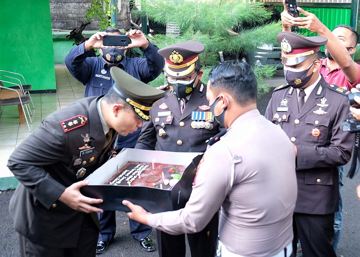 Anggota Polresta Sidoarjo membawakan kue tart ucapan HUT TNI. SP/Sugeng