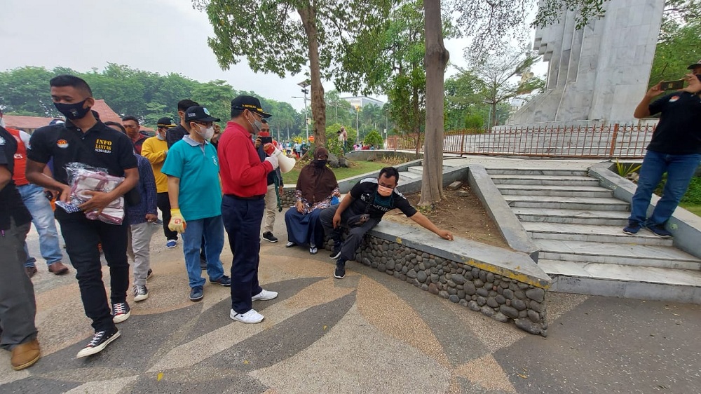Dengan berbekal pengeras suara, Pj. Bupati Hudiyono keliling alun-alun dengan membawa masker