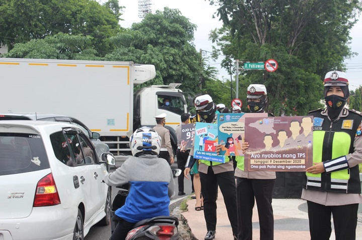 Sejumlah polwan berjejer di pinggir jalan sambil membawa poster ajakan untuk mencoblos pada Pilkada 2020. SP/Sugeng