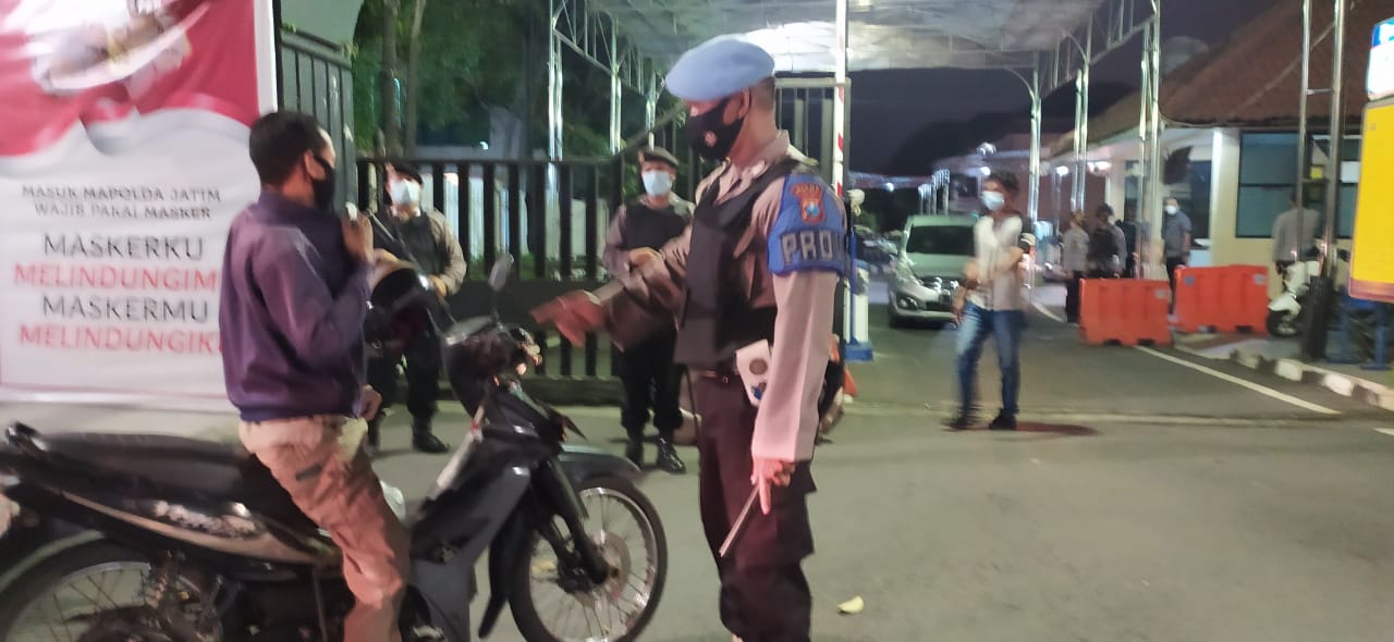 Petugas melakukan pemeriksaan terhadap orang yang akan masuk Mapolda Jatim atau yang akan keluar Mapolda Jatim Kamis (1/4/2021) 