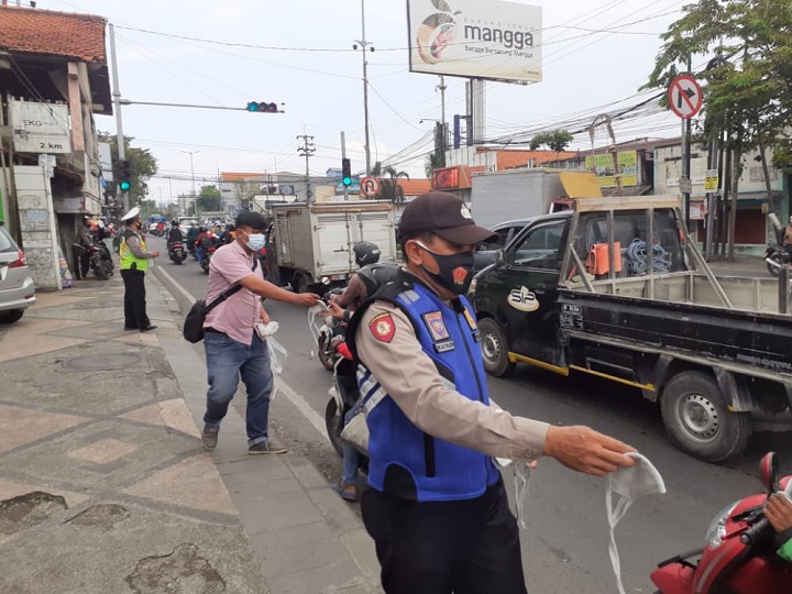 Jajaran Polresta Sidoarjo membagikan masker kepada para pengendara. SP/Sugeng Purnomo