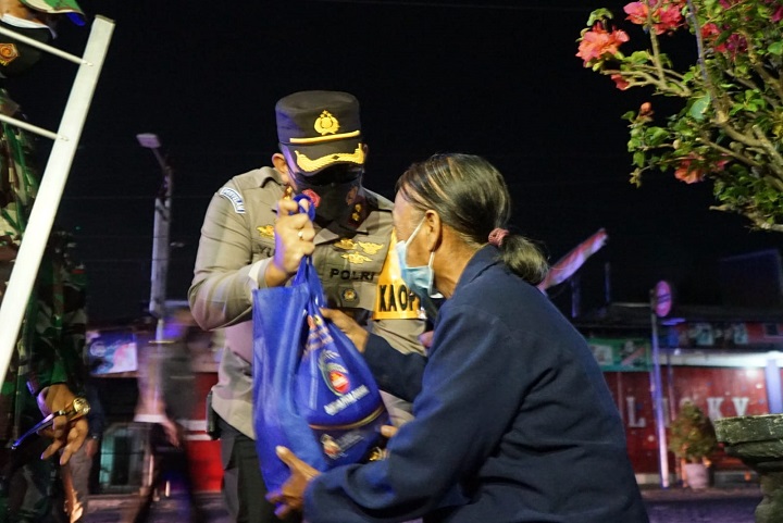 Kapolres Blitar Kota AKBP Yudhi Hery Setyawan bagikan bansos berupa beras pada salah satu ibu pedagang. SP/Hadi Lestariono
