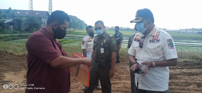 Petugas Satpol PP Kota Pasuruan menutup lokasi proyek perumahan di Kelurahan Sebani, Kota Pasuruan, Kamis (22/7/2021).