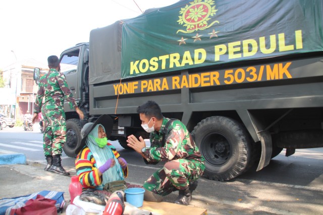 Prajurit TNI Yonif Para Raider 503/Mayangkara memberikan bantuan paket sembako dan nasi kotak kepada masyarakat yang terdampak PPKM. SP/Dwy Agus Susanti