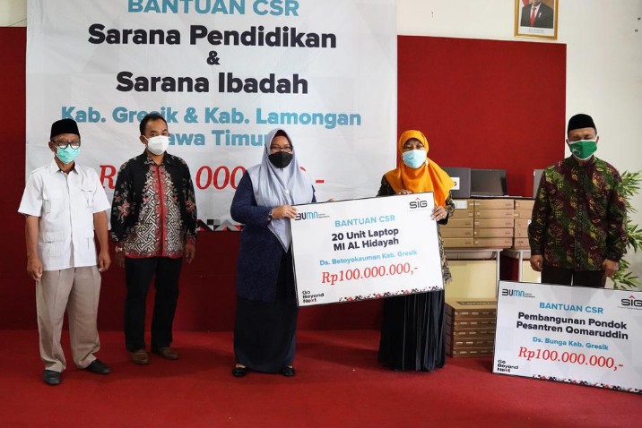 General Manager of CSR SIG Edy Saraya (dua dari kiri), Wakil Bupati Gresik Aminatun Habibah (tiga dari kiri) saat menyerahkan bantuan di SMK Qomarudin, Jumat (6/8). SP/SIG