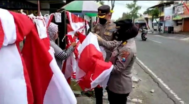 Anggota Polres Blitar Kota memborong bendera merah putih yang dijual warga. SP/Hadi Lestariono
