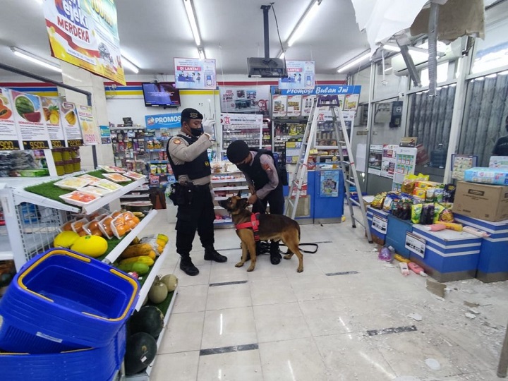 Petugas saat melakukan olah TKP di minimarket yang dibobol maling. 