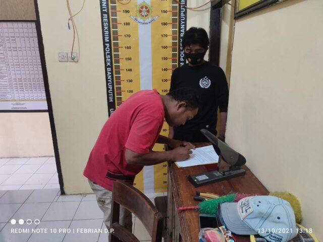 Pelaku penganiayaan Rahmad Hidayat, saat menulis surat pernyataan di Mapolsek Banyuputih.