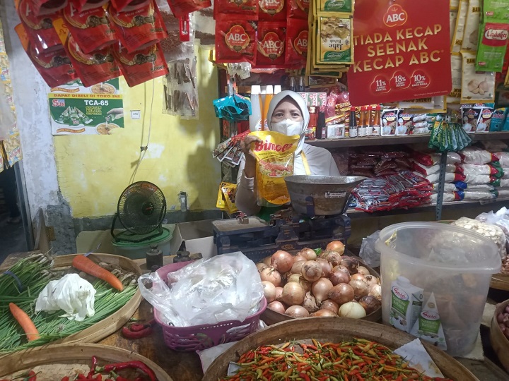 Pedagang di Pasar Sidoharjo Lamongan saat menunjukan kemasan minyak goreng yang alami kenaikan terus. SP/MUHAJIRIN KASRUN