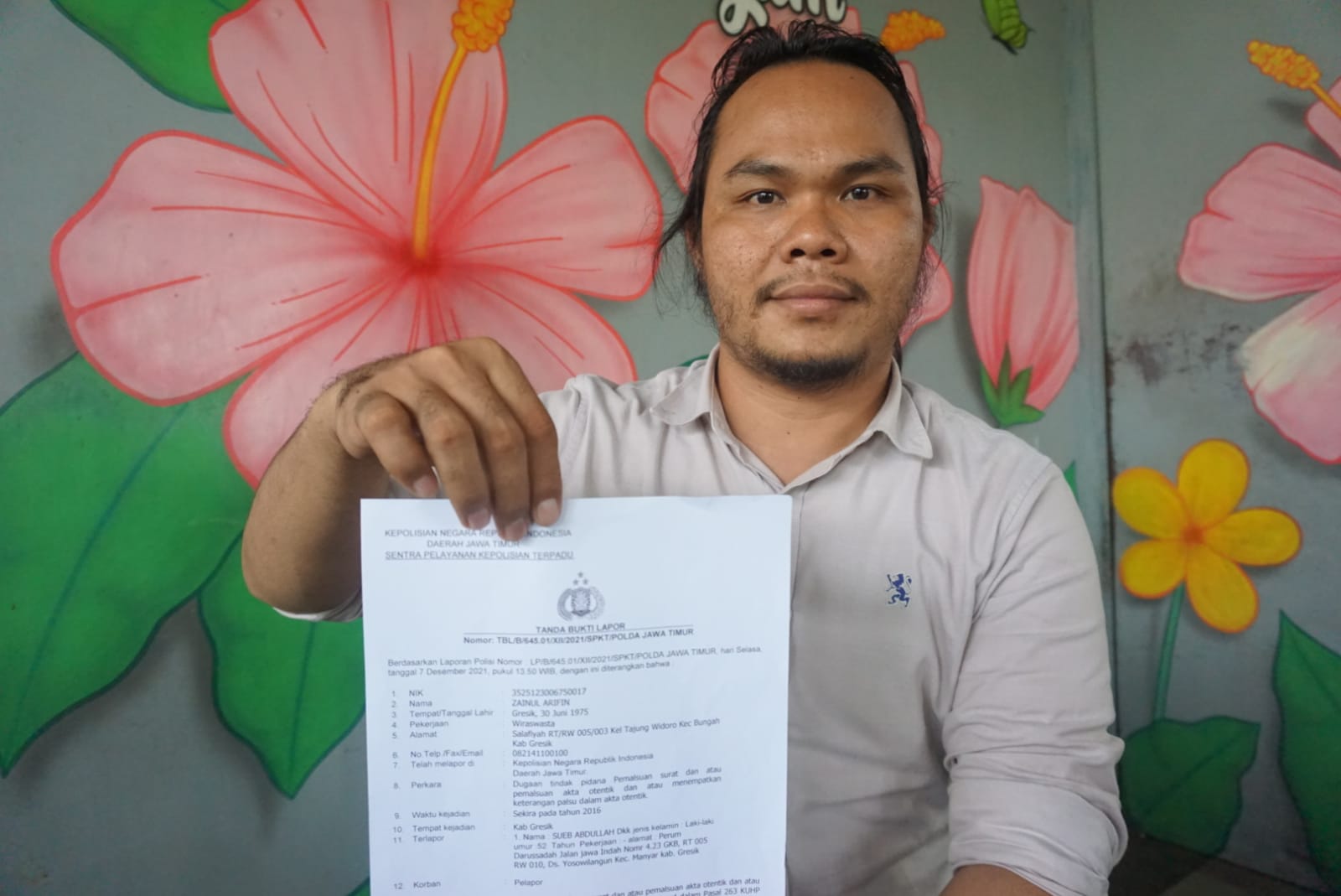 Pengacara Zainul Arifin, Umar Said menunjukkan bukti laporan akta jual beli tanah ke Polda Jatim