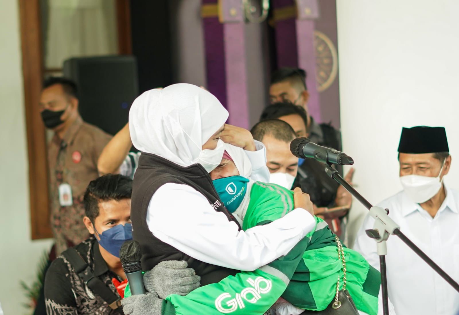 Gubernur Jawa Timur, Khofifah Indar Parawansa merangkul salah satu Srikandi Grab yang tergabung dalam Komunitas Gaspol usai menyerahkan donasi berupa paket sembako selama satu tahun.