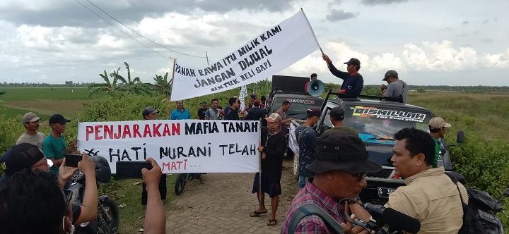 Dengan membentangkan spanduk, massa juga mendatangi lahan yang dijadikan tambak. SP/MUHAJIRIN 