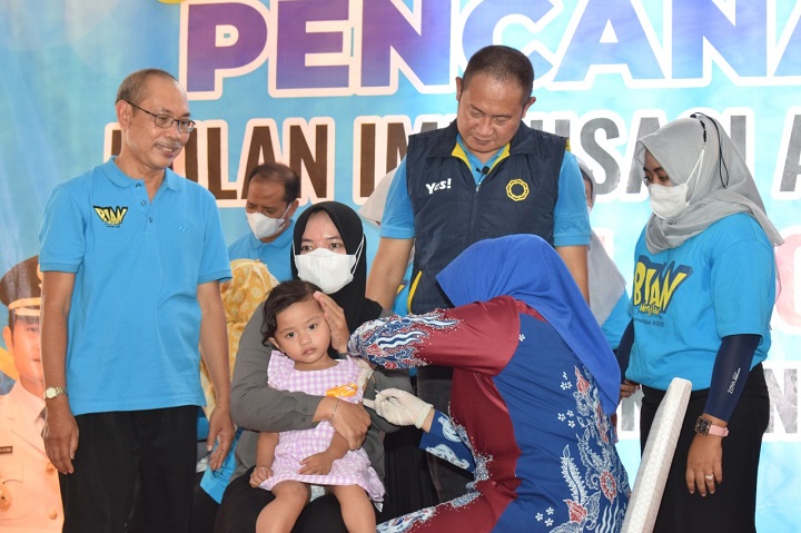 Istri bupati Anis Kartika Yuhronur Efendi saat memberikan langsung imunisasi ke anak.  SP/MUHAJIRIN KASRUN