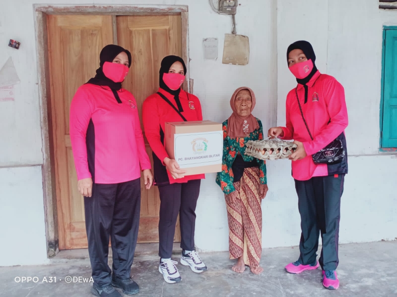 Ketua Bhayangkari ranting Kanigoro Ny Binti Wahyuni memberikan bansos kepada warga. SP/Hadi Lestariono