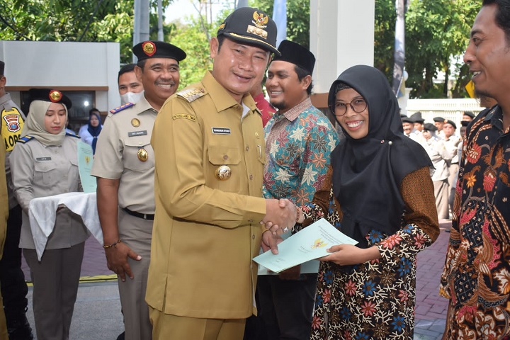 Bupati saat menyerahkan sertifikat ke perwakilan masyarakat di sela acara Hartaru di Kantor ATR/BPN. SP/MUHAJIRIN KASRUN