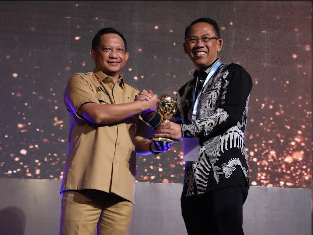 Sekdakot Mojokerto Gaguk Tri Prasetya saat mewakili Walikota Mojokerto Ika Puspitasari menerima UHC Award 2023