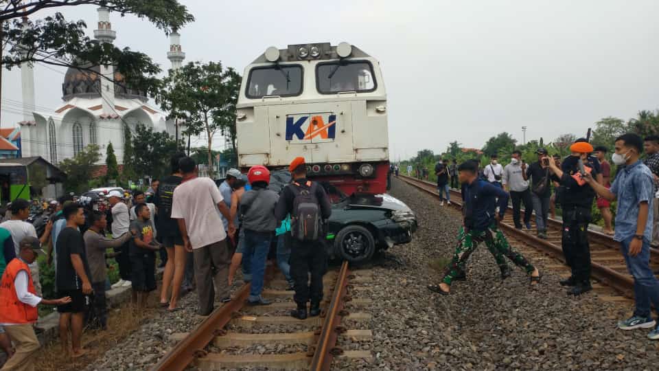 Evakuasi mobil sedan dilalukan oleh warga bersama aparat TNI Polri.

