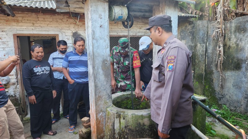 Petugas saat mendatangi sumur tempat korban mengakhiri hidupnya. SP/Lestariono 