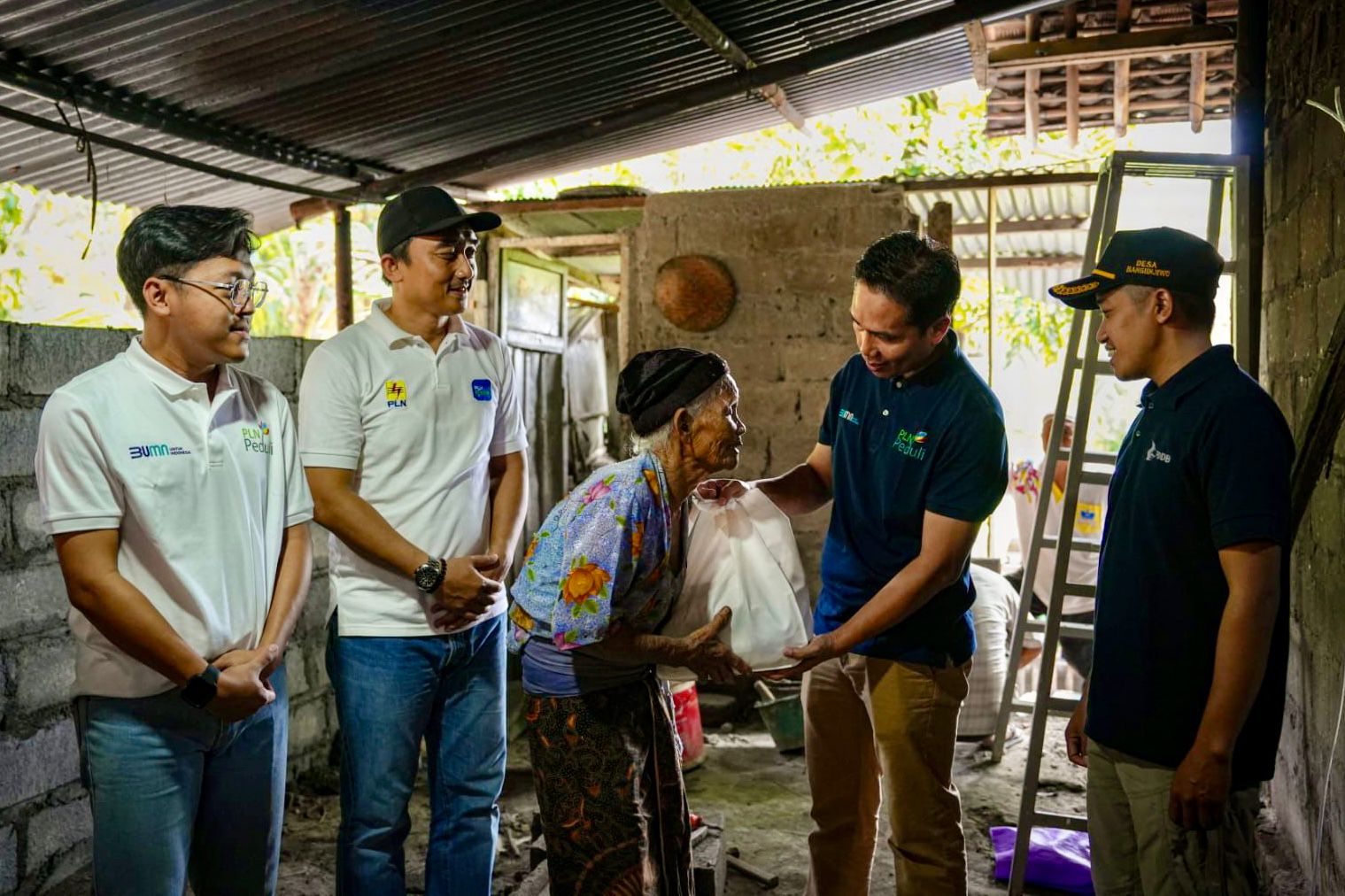 Selain mendapatkan bantuan renovasi rumah, Mbah Ponem (80) juga mendapatkan bantuan sembako dari PLN. Kiri ke kanan : Hasbi Hidayatullah (Pegawai PLN UID Jateng & DIY), Adi Dwi Laksono (Manager PLN UP3 Yogyakarta), Ponem (Penerima bantuan renovasi rumah),