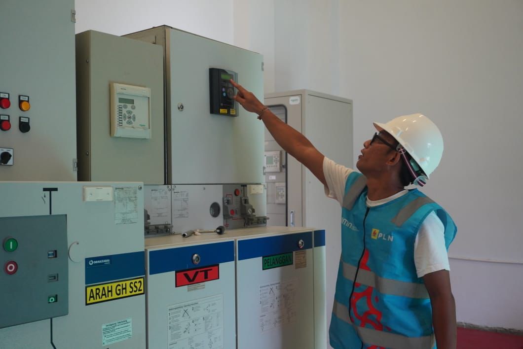 Petugas melakukan pemeriksaan beban pemakaian listrik pada UPS portable di salah satu venue KTT AIS. Foto/Humas PLN