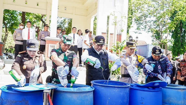 Bupati bersama Kapolres dan jajaran Forkopimda saat membuang botol minuman berisi bir. SP/ MUHAJIRIN 