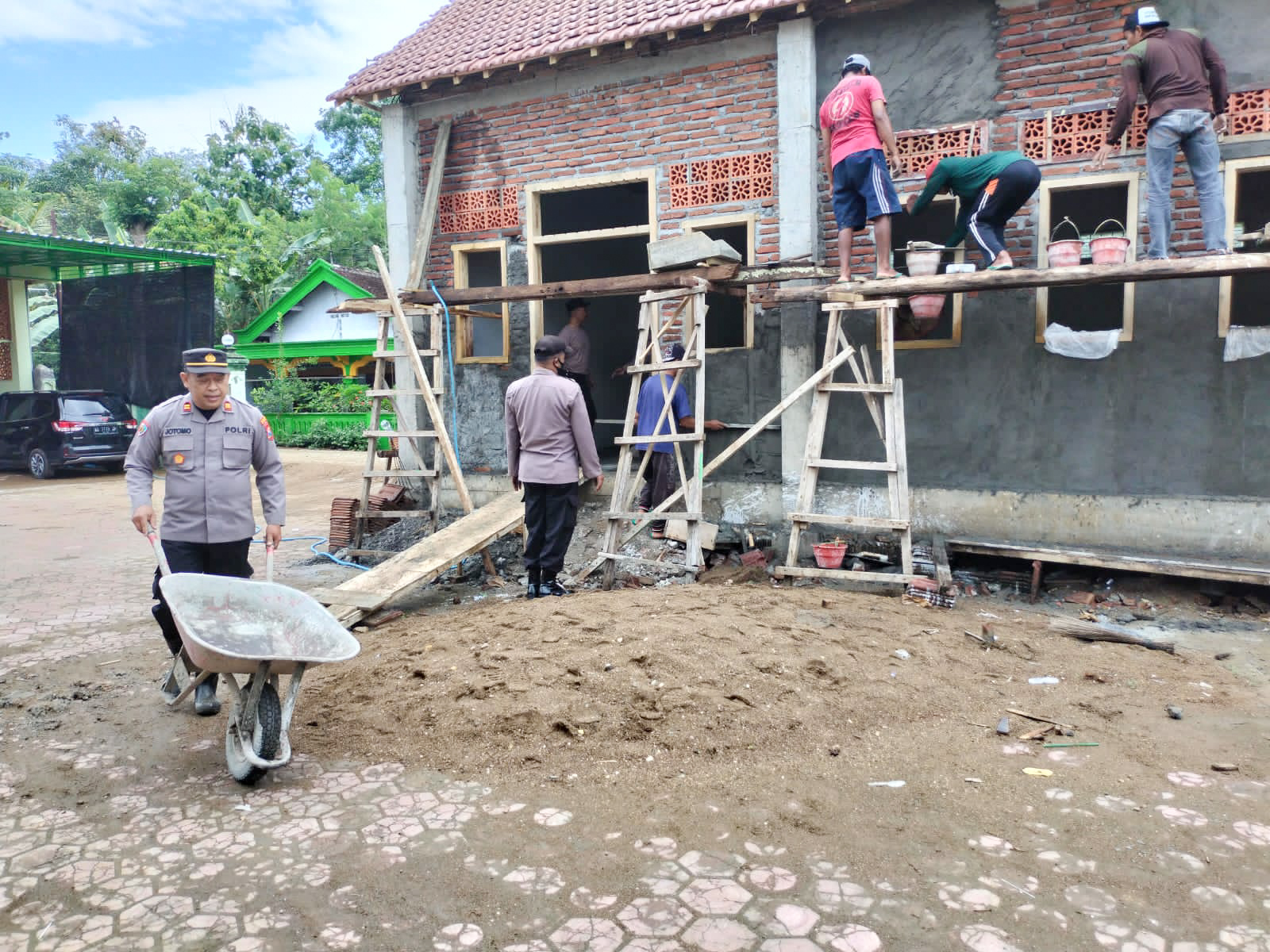 Anggota Polsek Karangan saat membantu proses pembangunan ponpes Darul Muttaqin di Trenggalek, Kamis, (19/01/2023). Foto: SP/Ariandi.