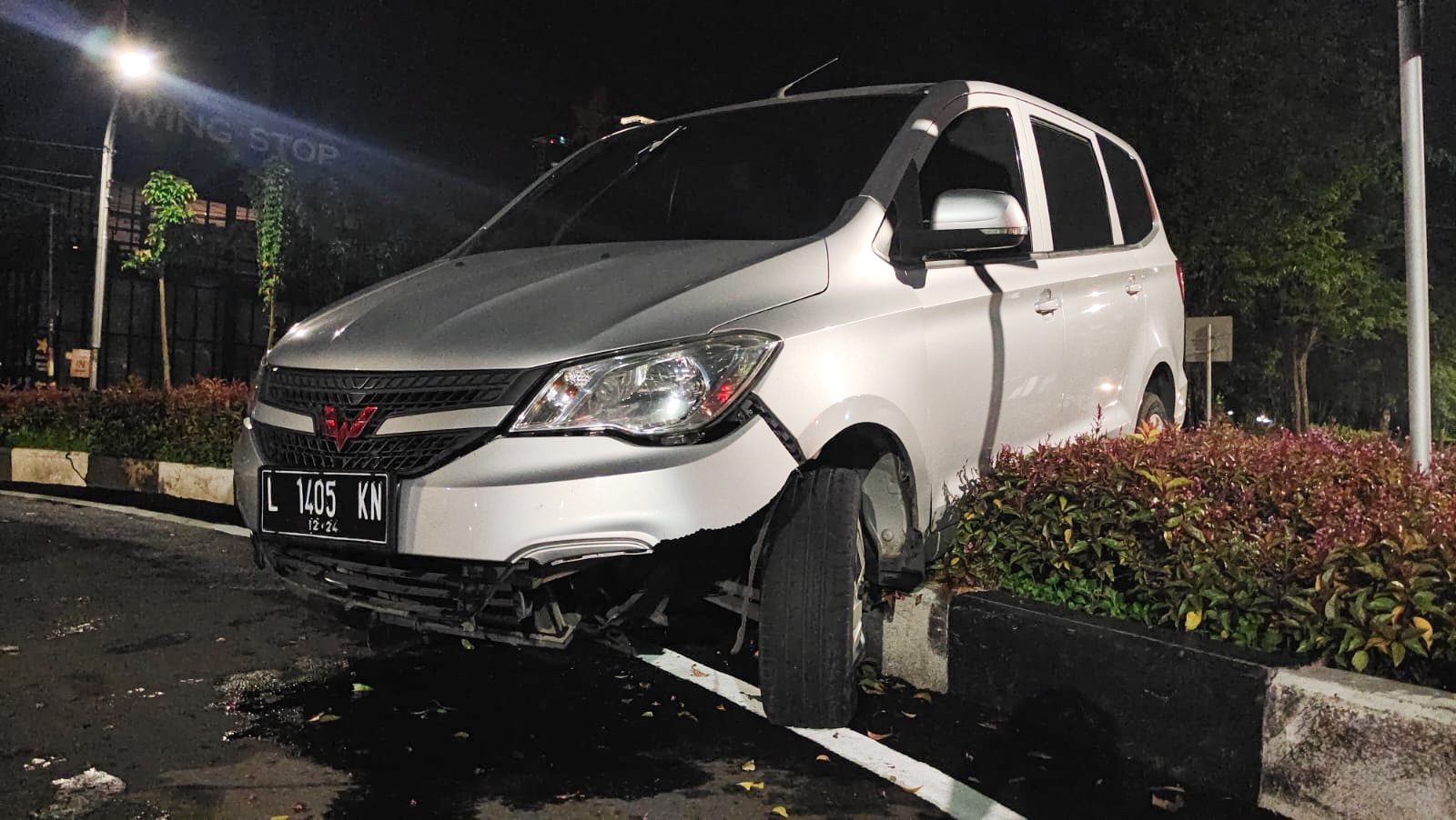 Kondisi mobil Wuling yang naik ke pambatas jalan di jalan Raya Kertajaya Indah, Surabaya, Jum'at (27/1/2023). SP/Ariandi.