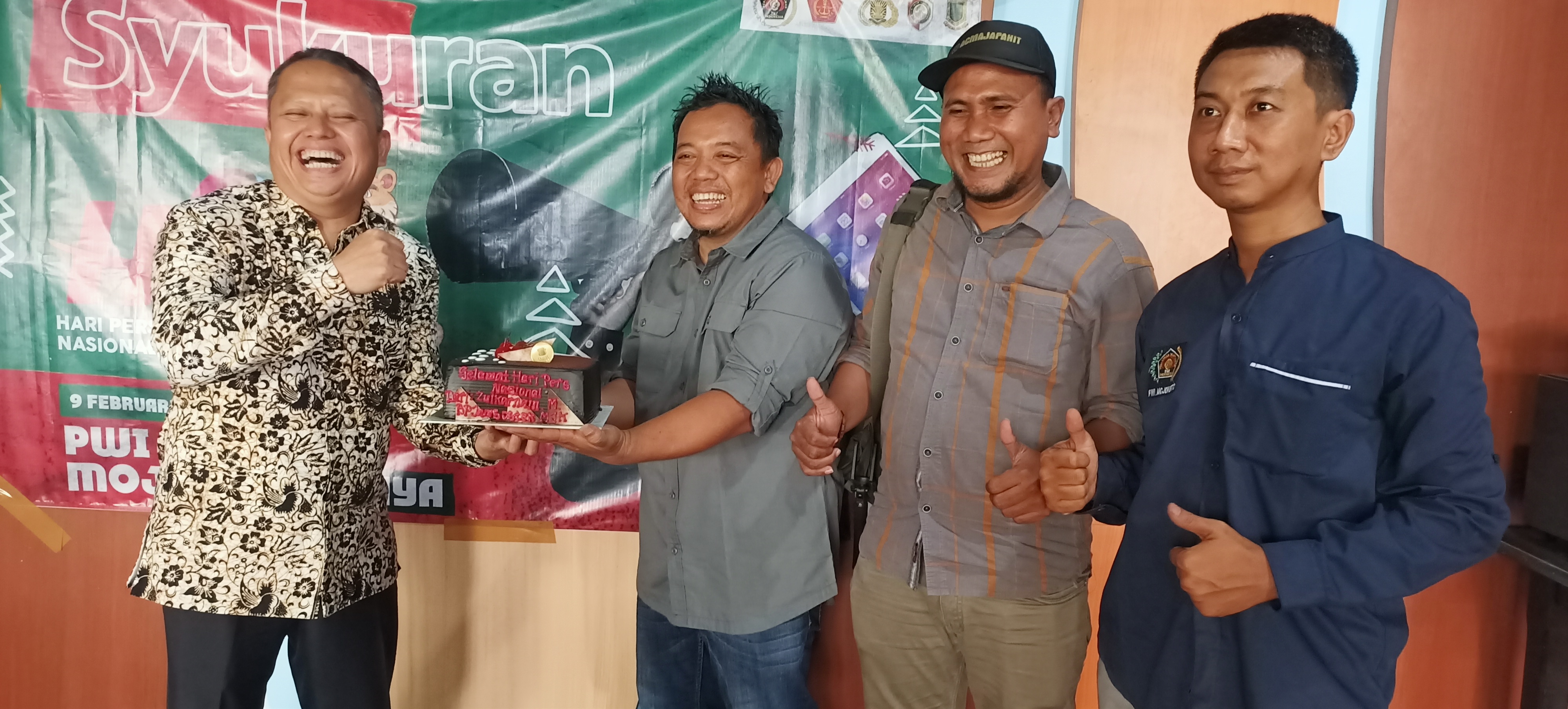 Kepala BPJS Ketenagakerjaan Mojokerto, Zulkarnain Mahading saat menyerahkan kue tart ucapan HPN tahun 2023 kepada Ketua PWI Mojokerto, Sholahudin