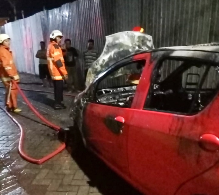 Petugas usai memadamkan api yang membakar mobil. SP/Ariandi