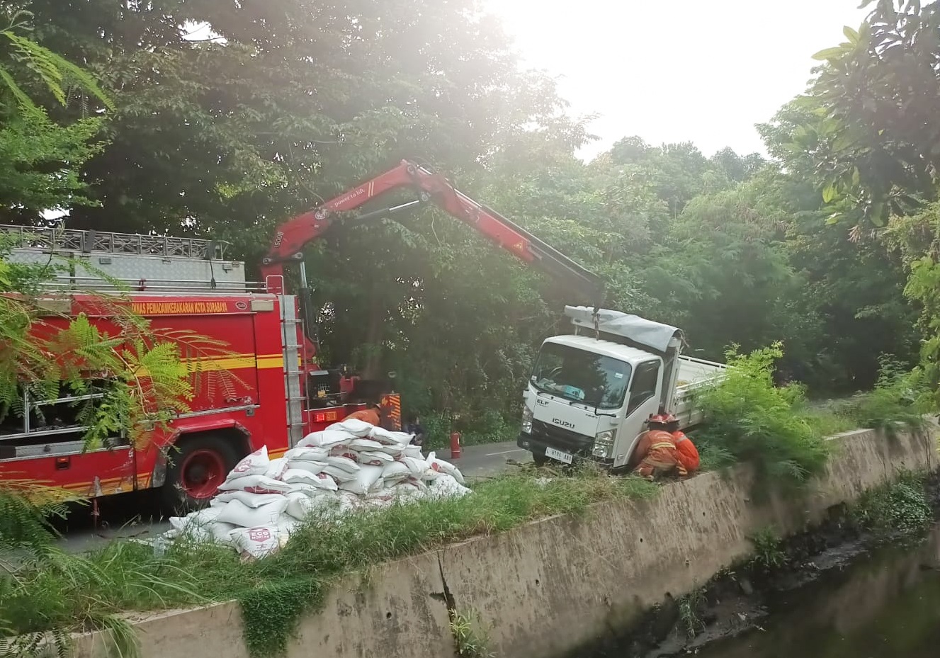 Proses evakuasi truk Isuzu yang terperosok ke sungai di jalan Semolowaru Bahari Surabaya, Sabtu, (17/12/2022).