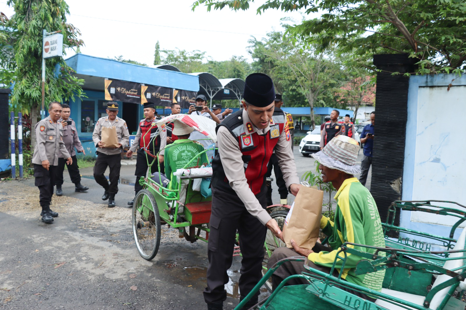 Kapolres Pamekasan AKBP Satria Permana saat membagikan sembako untuk tukang becak di pinggir jalan. Foto: SP/Ariandi.