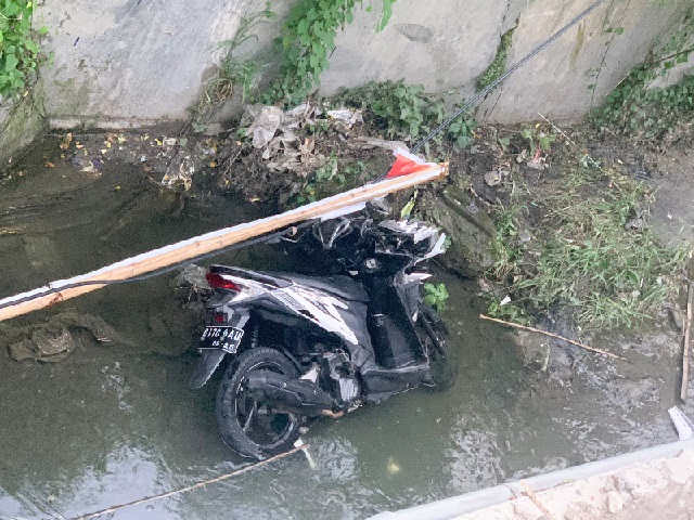 Sepeda motor yang tercebur di sungai Jalan Lidah Wetan Surabaya, Sabtu (25/2/2023). Foto: SP/Ariandi.