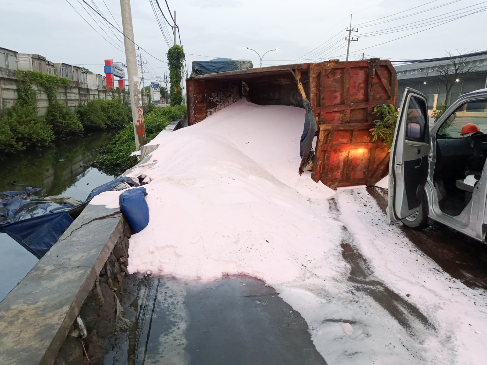 Dump truk bermuatan pupuk urea yang  terguling di Jalan Tambak Osowilangon, Minggu (27/11/2022).