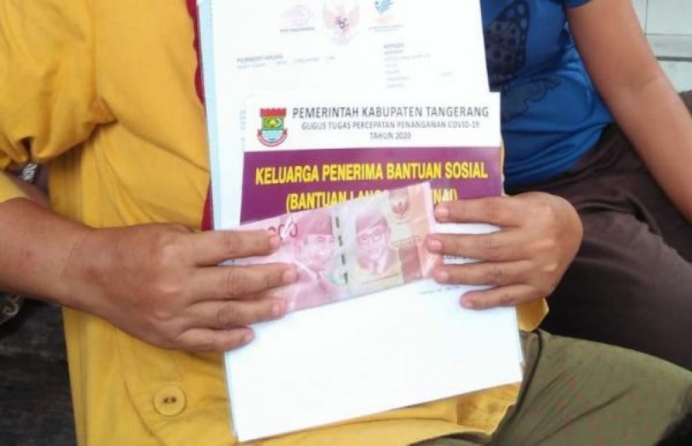 Salah satu Penerima bantuan sosial terdampak Covid-19 di Desa Talok Kecamatan Kresek Kabupaten Tangerang menunjukkan uang setelah dipotong oknum RT setempat.