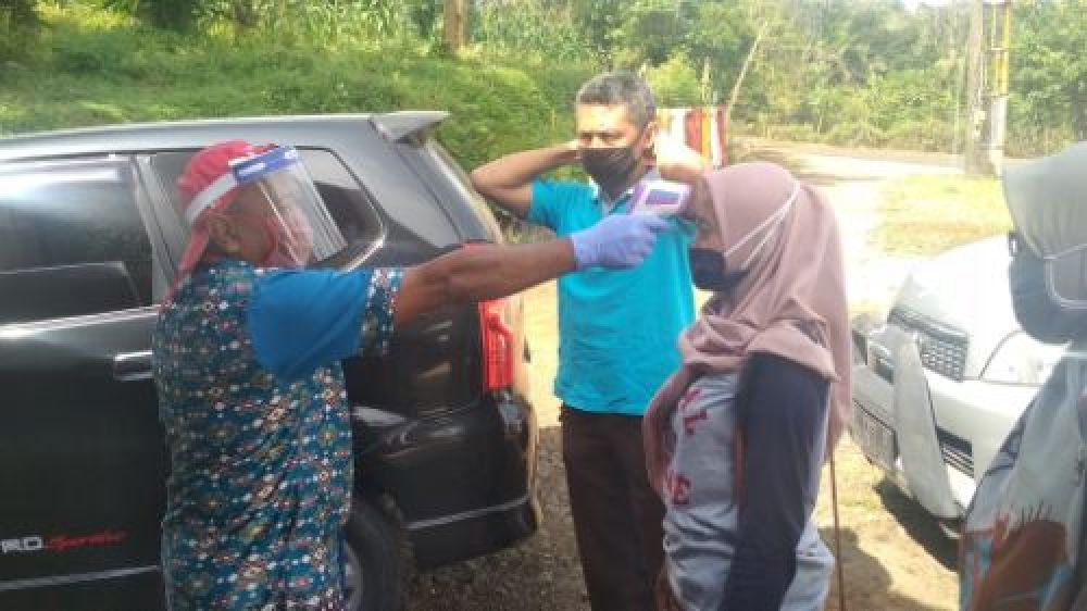 Pengunjung tempat wisata Banyu Mili, Wonosalam saat diperiksa suhu tubuhnya. (SP/M. Yusuf) 