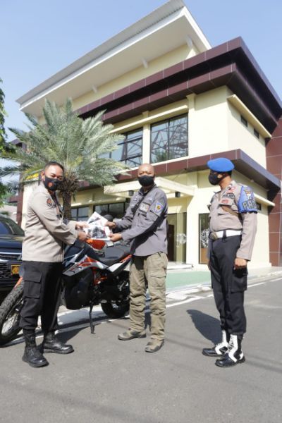 Kabidhumas Polda Jatim Kombes Pol Trunoyudo Wisnu Andhiko memberikan masker kepada Gunadi Indonesia Overlander Forum Selasa (18/8/2020)