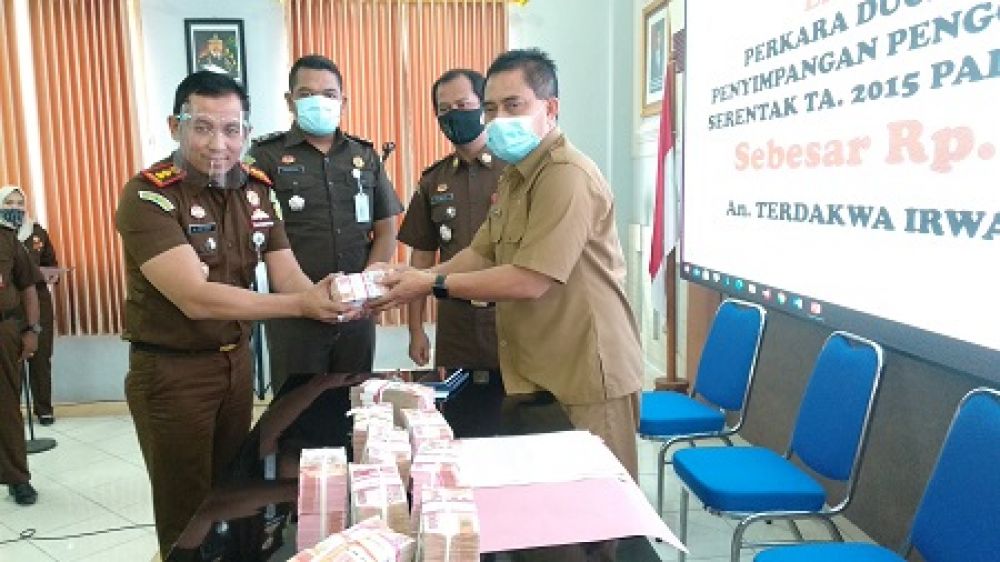 Kepala Kejaksaan Negeri Lamongan Agus Setiadi saat menyerahkan secara simbolis uang pengembalian hasil korupsi ke Plh Sekda Hery Pranoto. SP/MUHAJIRIN