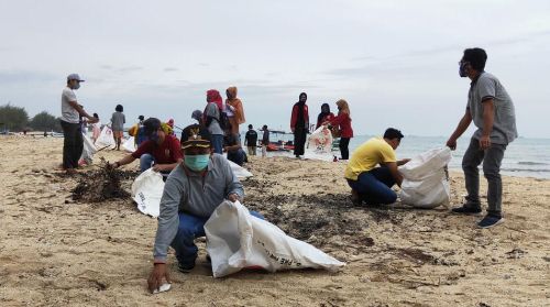Kepala Desa Tasikharjo, Damuri, saat membersihkan Pantai Panduri bersama warga dan karangtaruna.