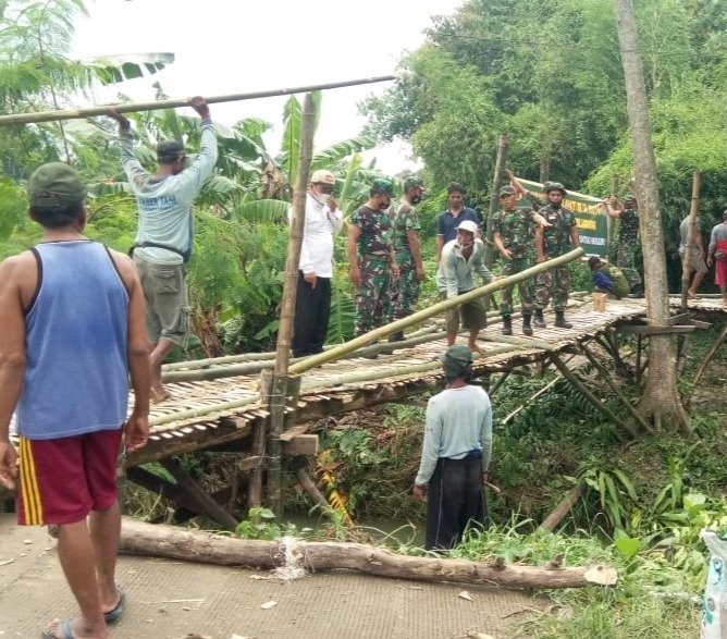 Warga dibantu TNI membangun jembatan alternatif secara swadaya.