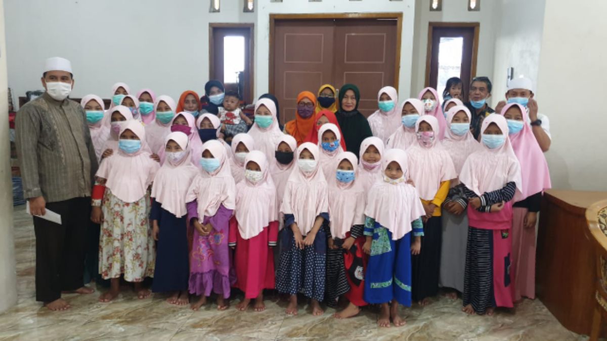 Para istri wartawan berfoto bersama anak-anak yatim piatu usai memberikan santunan.