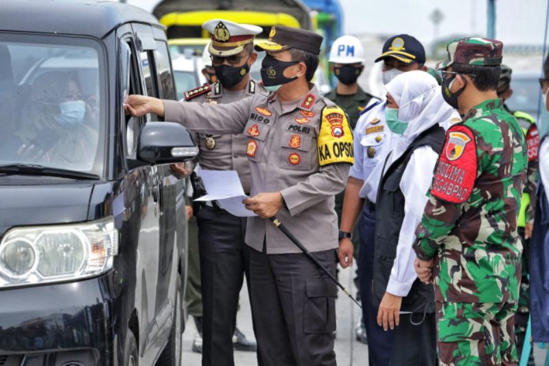Gubernur Jatim Khofifah Indar Parawansa, Kapolda Jatim Irjen Pol Nico Afinta dan Pangdam V Brawijaya Mayjen TNI Suharyanto membagikan masker kepada warga Bangkalan, Minggu (13/6/2021)