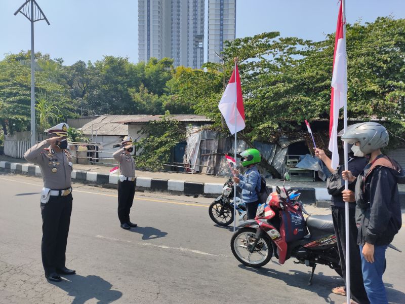 Dirlantas Polda Jatim Kombes Pol Usman Latief bersama para pengguna jalan melakukan hormat kepada bendera merah putih, Selasa (17/8/2021)