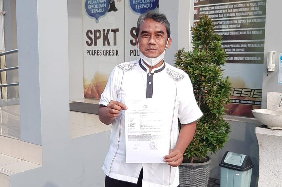 Mu'alim, sekretaris AMPG menunjukkan bukti LP usai keluar dari ruangan SPKT Polres Gresik, Rabu (15/6) sore.