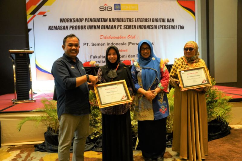 General Manager of CSR SIG, Edy Saraya didampingi Kepala Dinas Koperasi, Usaha Mikro, dan Perindag Gresik, Malahatul Fardah (ketiga kiri) menyerahkan sertifikat Pelatihan kepada Dinda Intan Lestari (kedua kiri).