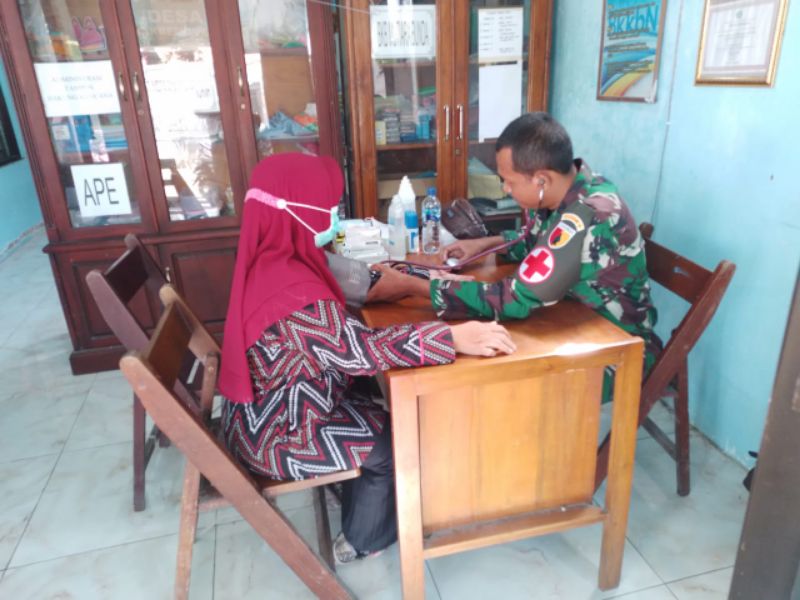 Anggota Satgas TMMD membantu dalam pengecekan kesehatan anggota satgas TMMD dan warga Desa Rejeni.