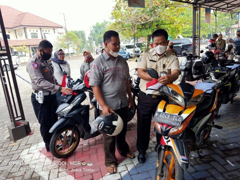 Petugas Samsat Bangil saat berikan Bendera merah putih kepada kendaraan wajib pajak.