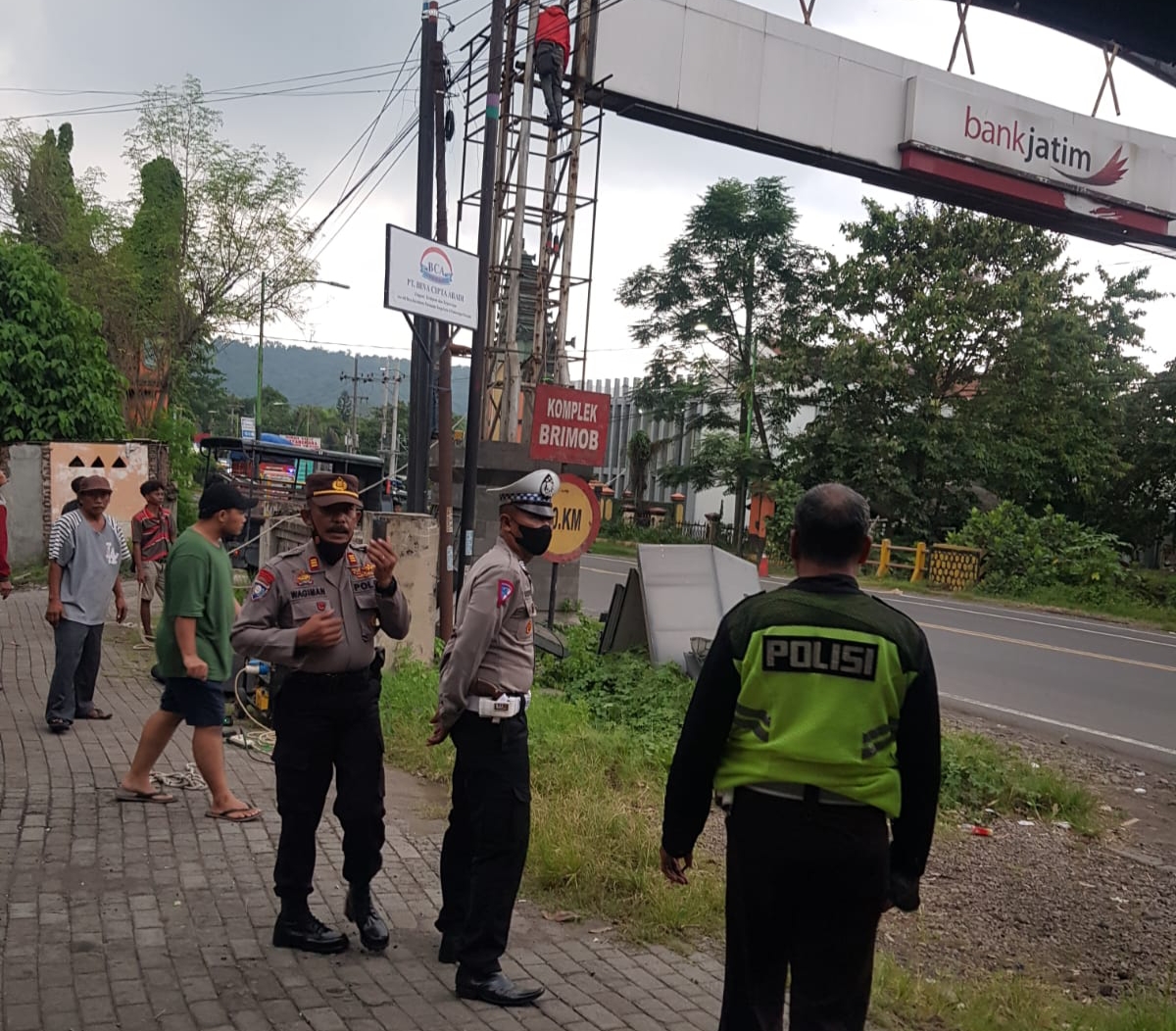 Aparat kepolisian dan petugas dari instansi terkait saat mengawasi proses perobohan gapura perbatasan