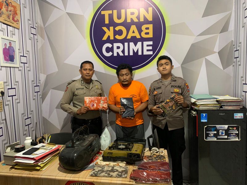 Tersangka Wawan diapit dua petugas Polsek Cerme dengan sejumlah barang curian yang berhasil disita dari tangannya.
