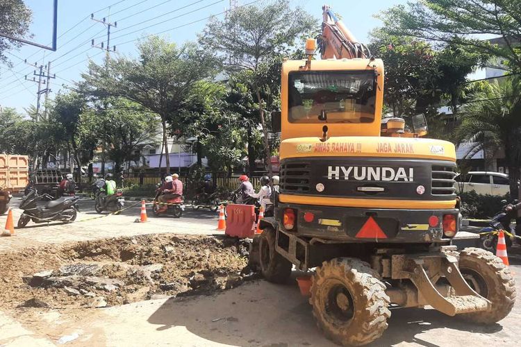 Alat berat jenis Eskavator menguruk 'ledakan' Jalan Pasar Kembang Surabaya, akibat proyek pipa bawah tanah milik PDAM Surabaya, Selasa (1/8/2023) pagi kemarin.